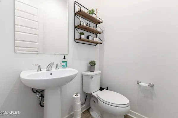 a bathroom with a sink a toilet and mirror