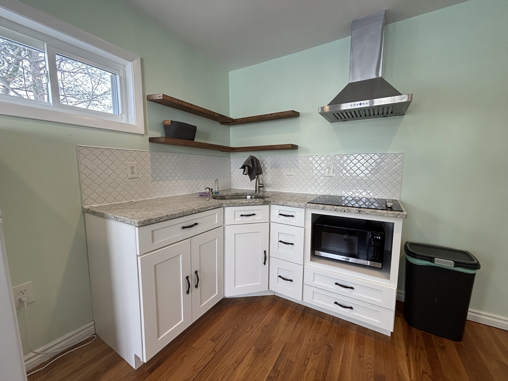 30 Alaric Street, Unit 2 Boston, MA 02132 - Photo 6 of 14 a kitchen with stainless steel appliances granite countertop a stove a sink and a microwave