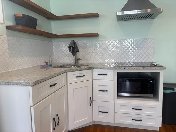 a kitchen with granite countertop a stove and a microwave