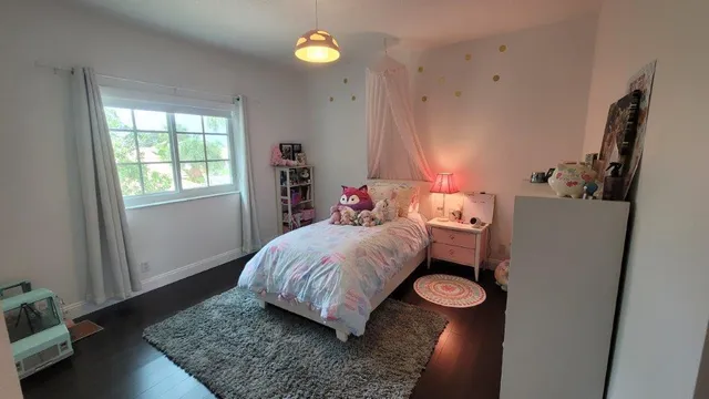 a bed sitting in a bedroom next to a window
