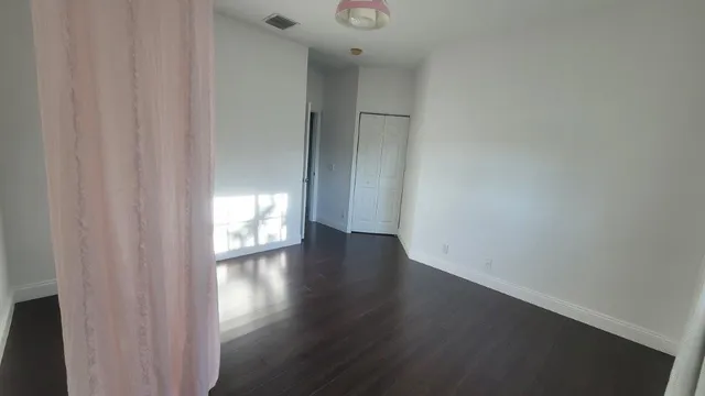 a view of an empty room and wooden floor