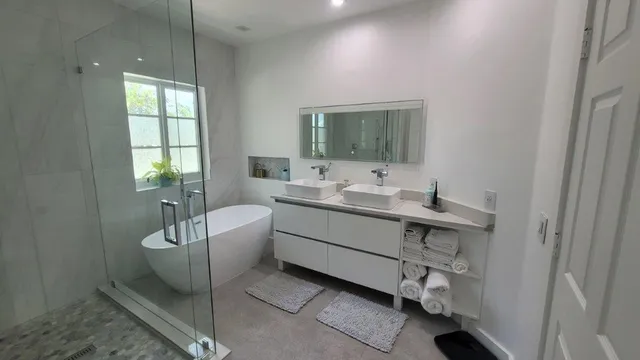 a bathroom with a double vanity sink a mirror and a bathtub