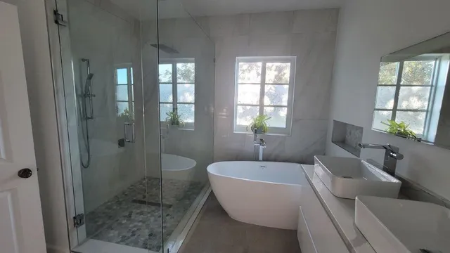 a spacious bathroom with a granite countertop tub mirror and window