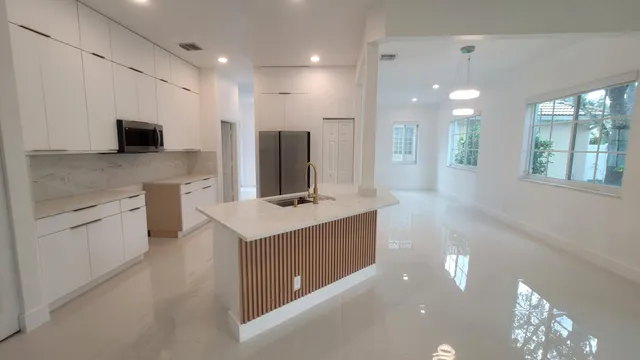 a large kitchen with a large counter top appliances and cabinets