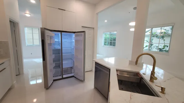 a kitchen with stainless steel appliances granite countertop a sink a stove and a refrigerator