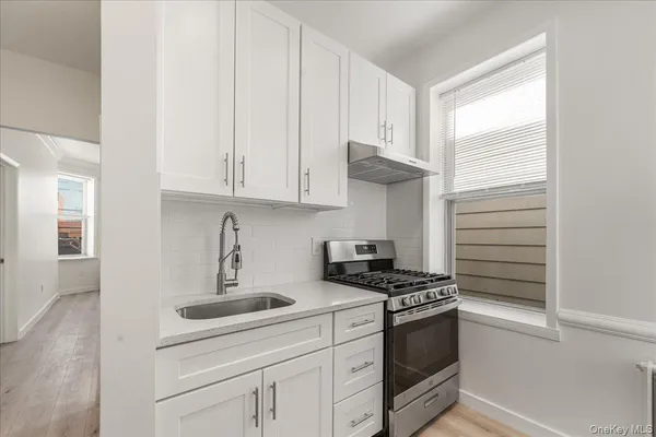 a kitchen with granite countertop white cabinets and white appliances