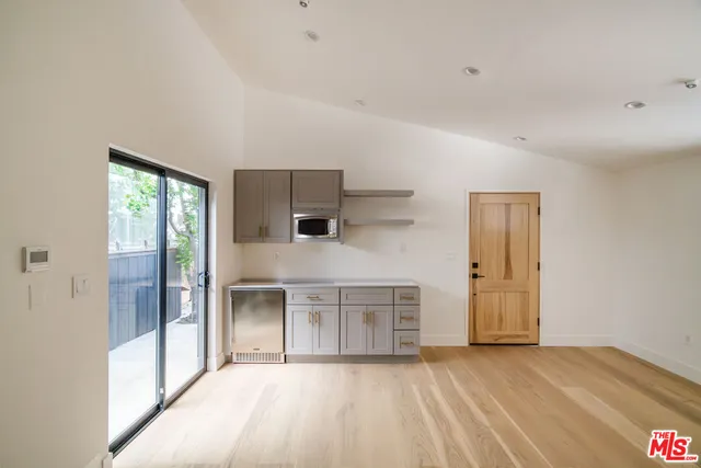 a view of a hallway with wooden floor and cabinet
