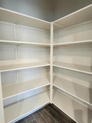 a view of walk in closet with empty racks
