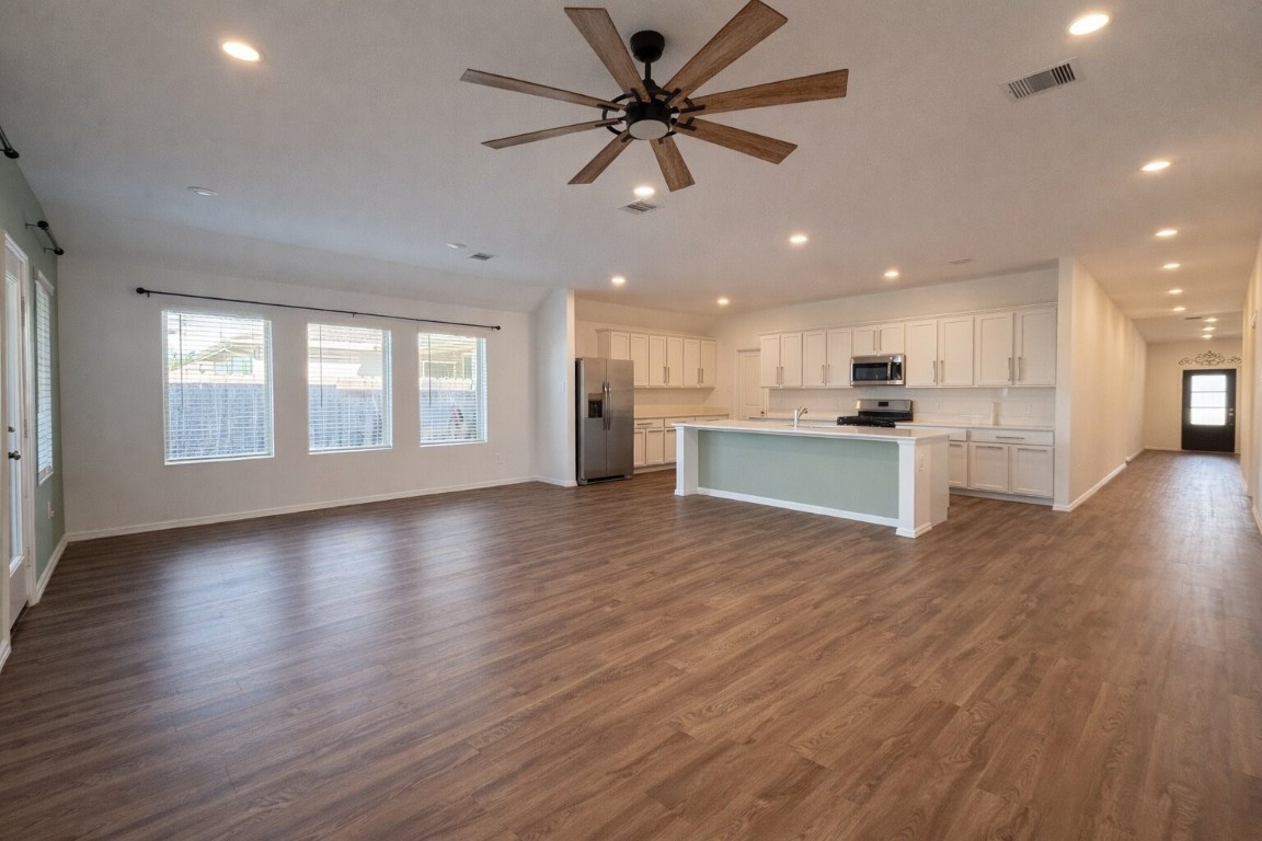 3105 Catalonion Court Conroe, TX 77301 - Photo 5 of 16 a view of an empty room with a kitchen and wooden floor