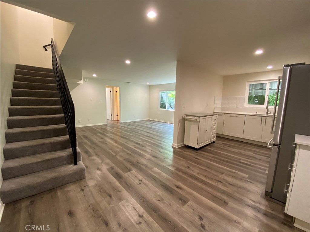 a view of a living room with wooden floor and stairs