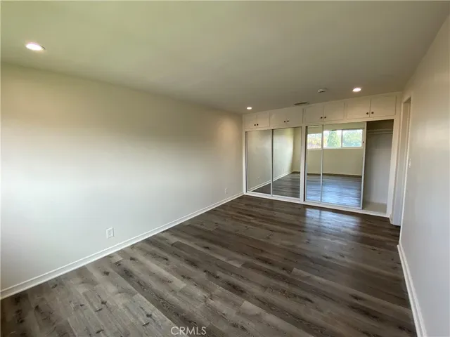 an empty room with wooden floor and natural light