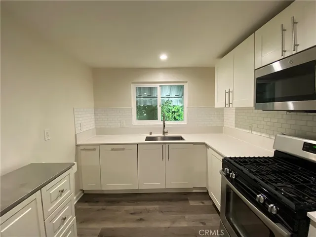 a kitchen with granite countertop a sink and a stove top oven