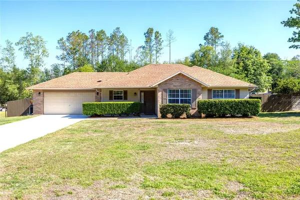 a front view of a house with a yard and trees