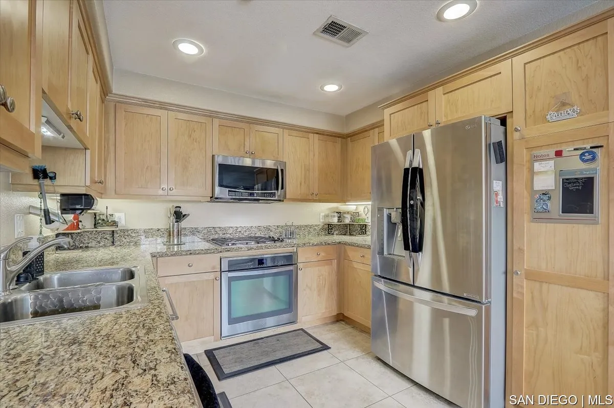 1213 Page Lane Santee, CA 92071 - Photo 7 of 21 a kitchen with stainless steel appliances granite countertop a refrigerator a stove top oven a sink and dishwasher