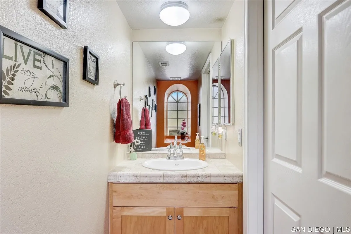 1213 Page Lane Santee, CA 92071 - Photo 8 of 21 a bathroom with a granite countertop sink and a mirror