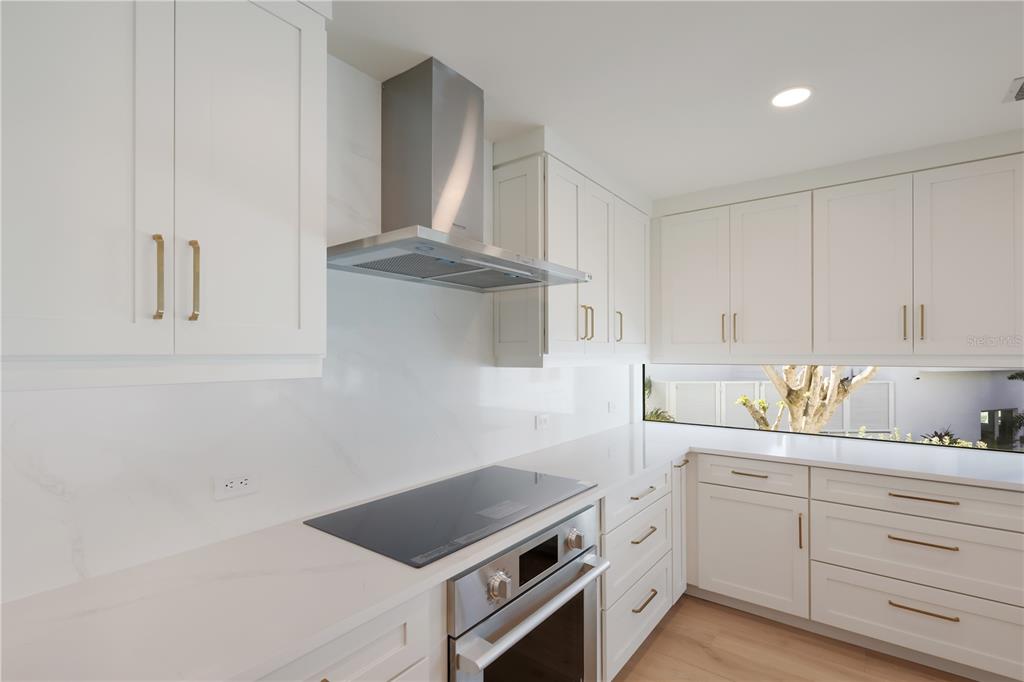 204 Waterway Avenue Boca Grande, FL 33921 - Photo 5 of 49 a kitchen with white cabinets and white appliances