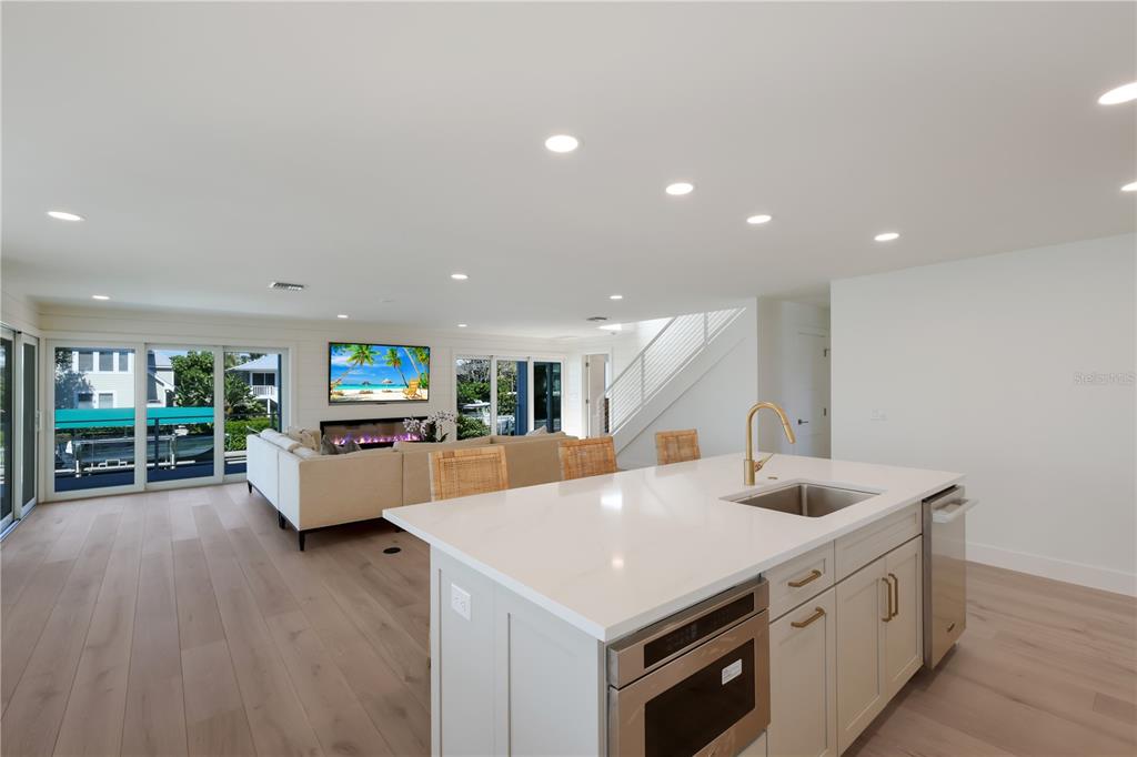 204 Waterway Avenue Boca Grande, FL 33921 - Photo 7 of 49 a kitchen with stainless steel appliances kitchen island wooden floors and white cabinets