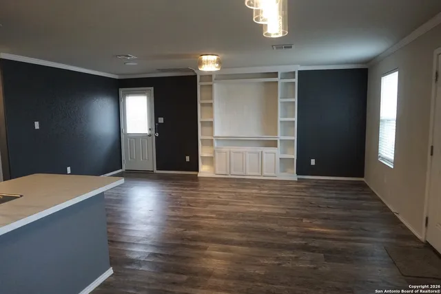 a view of empty room with wooden floor