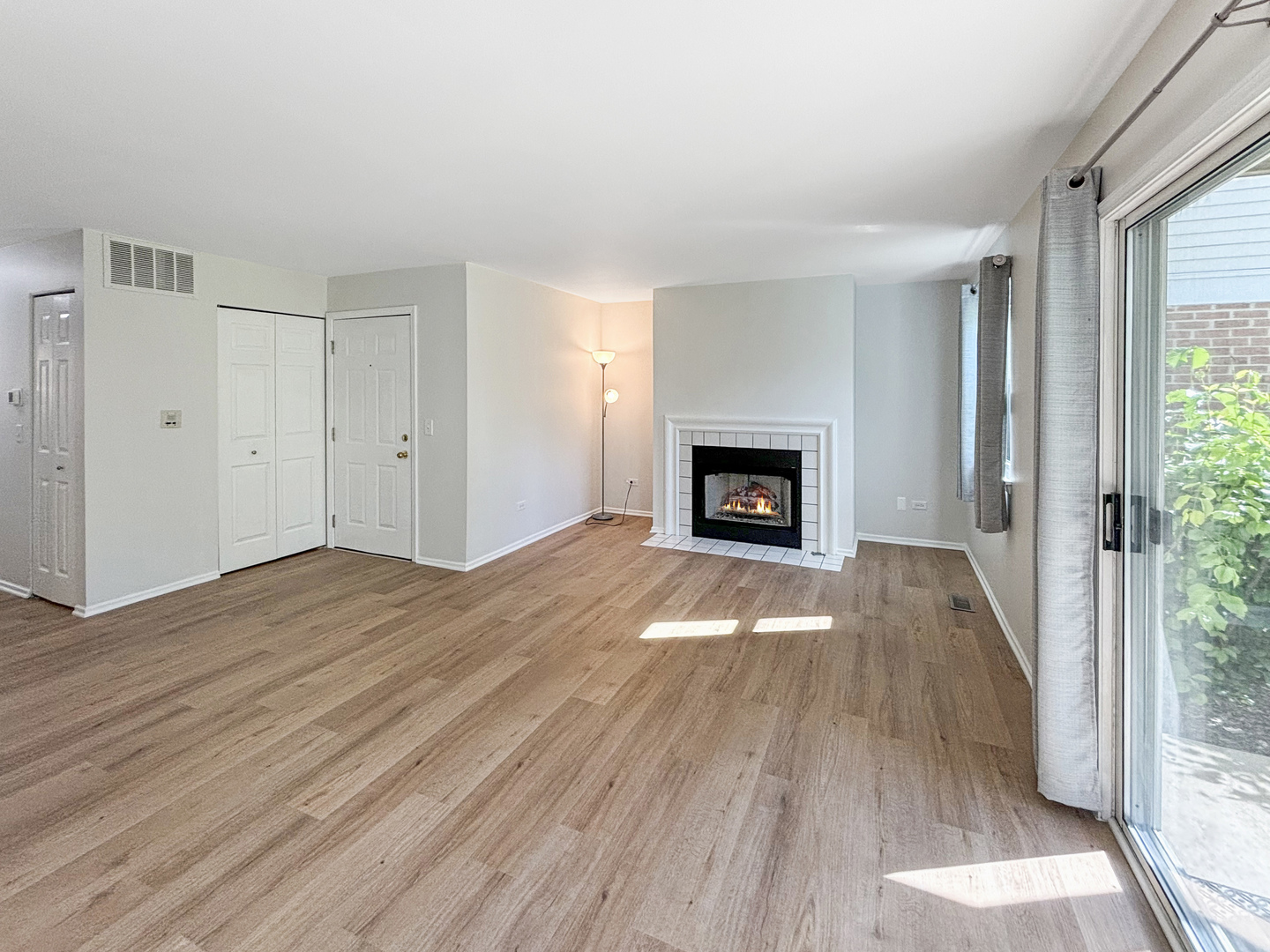 71 Larch Court, Unit B Schaumburg, IL 60193 - Photo 5 of 14 an empty room with wooden floor fireplace and windows