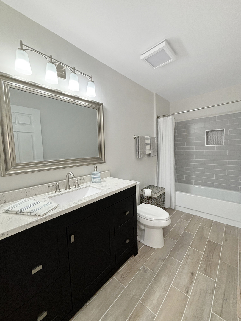 71 Larch Court, Unit B Schaumburg, IL 60193 - Photo 7 of 14 a bathroom with a double vanity sink toilet and mirror