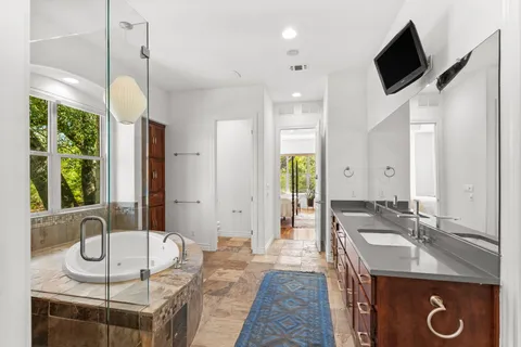 a bathroom with a tub a sink and a large mirror