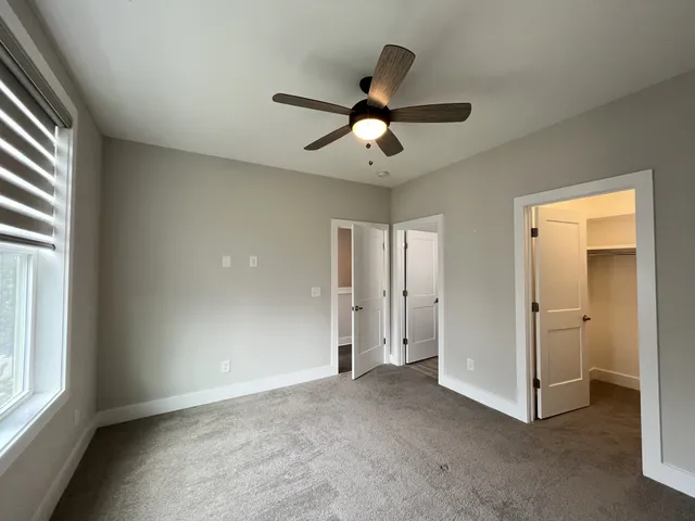a view of a livingroom with a ceiling fan and window