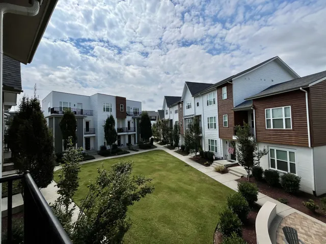 a view of a patio with table and chairs potted plants and floor to ceiling window