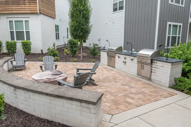 a view of a kitchen with granite countertop a stove a sink and white cabinets