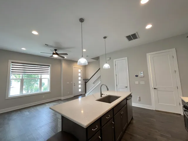 a kitchen with a stove a sink and wooden floor
