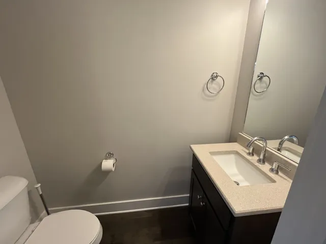 a bathroom with a sink mirror vanity and toilet