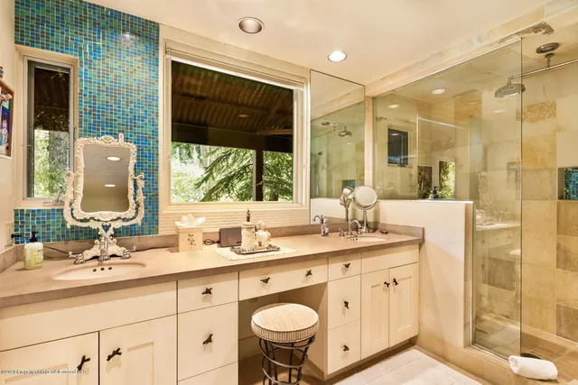 a bathroom with a double vanity sink mirror and shower