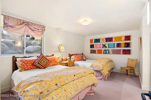 a bedroom with two beds and a painting on the wall