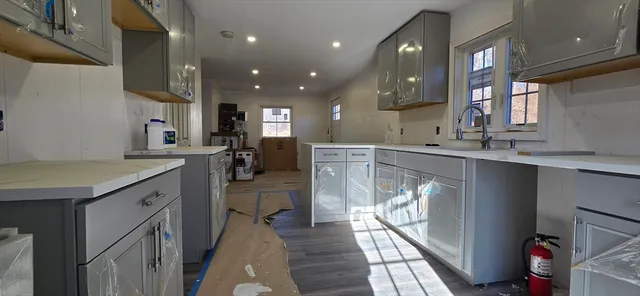 a kitchen with a sink stainless steel appliances cabinets and a counter top space
