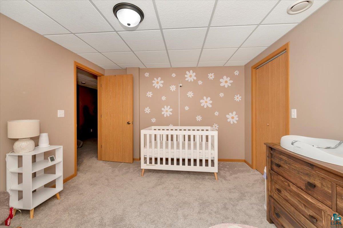 5992 Birchway Road Duluth, MN 55810 - Photo 23 of 36 Carpeted bedroom with a closet, a nursery area, and a paneled ceiling