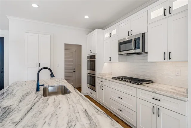 a view of kitchen with stainless steel appliances refrigerator stove microwave and cabinets