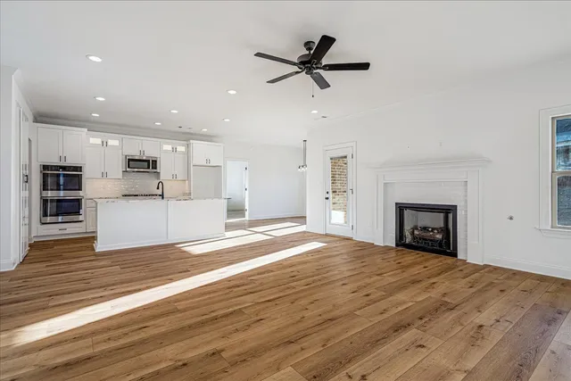 a view of empty room with a fireplace and wooden floor