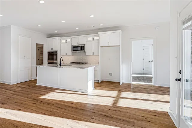 a view of a livingroom with a fireplace a ceiling fan and kitchen view