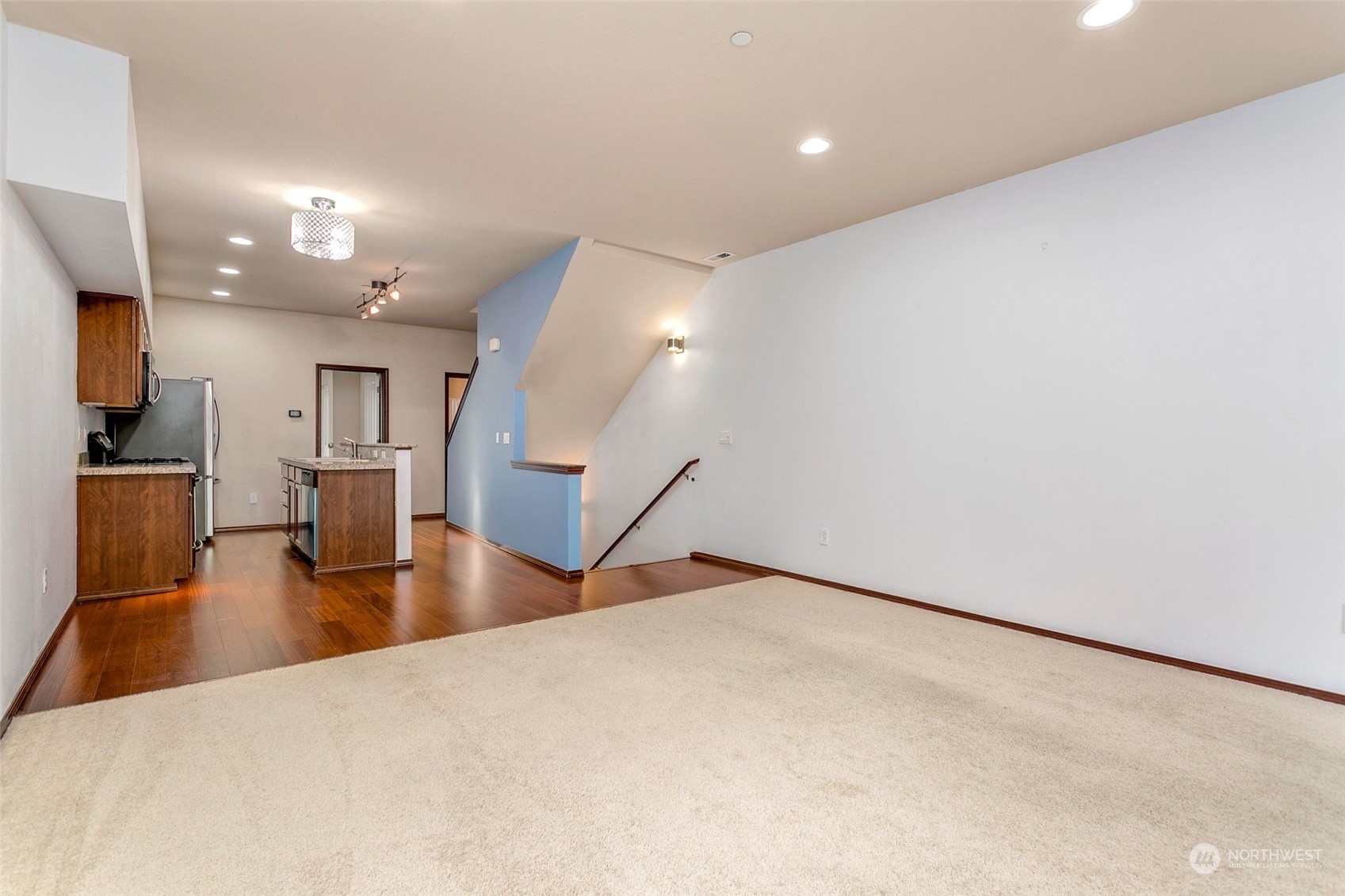 1137 215th Place Southeast Bothell, WA 98021 - Photo 4 of 30 an empty room with wooden floor and kitchen view