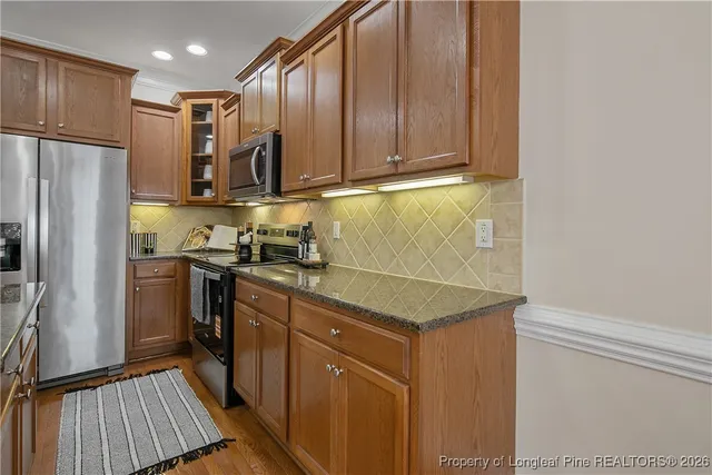 a kitchen with granite countertop a sink stove and cabinets