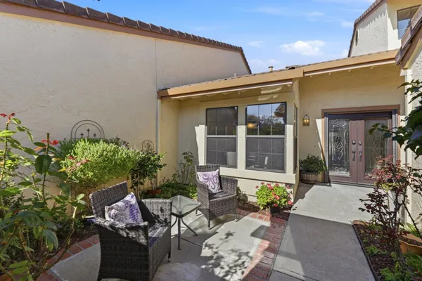a view of a patio with couches table and chairs and potted plants