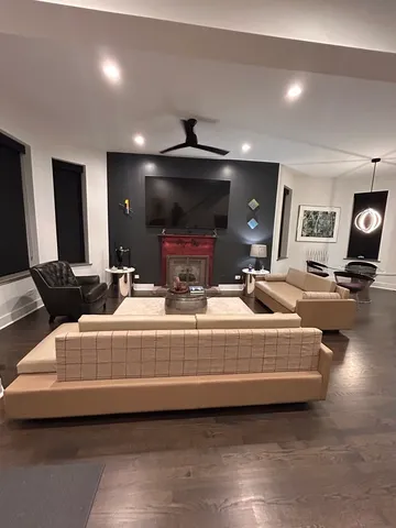 a living room with furniture a flat screen tv and kitchen view