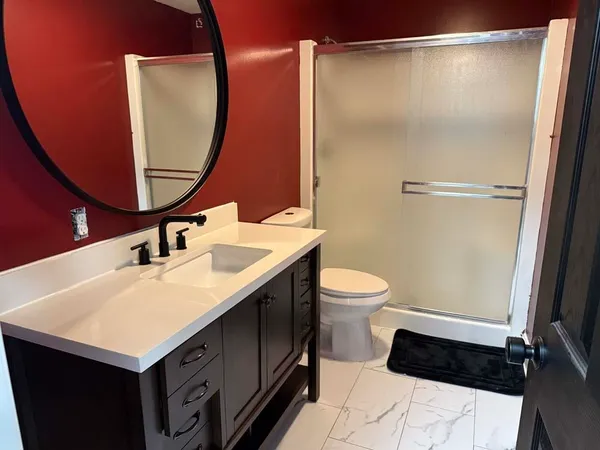 a bathroom with a sink a toilet and a mirror