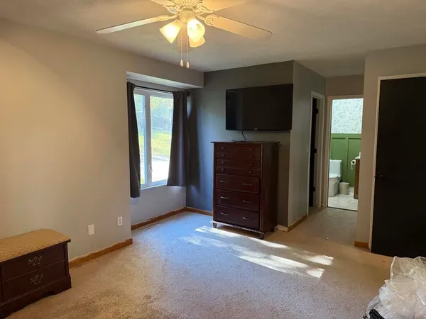 a room with a flat screen tv and a dresser