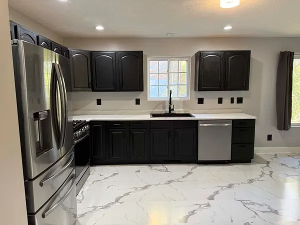 a kitchen with stainless steel appliances a sink and a refrigerator
