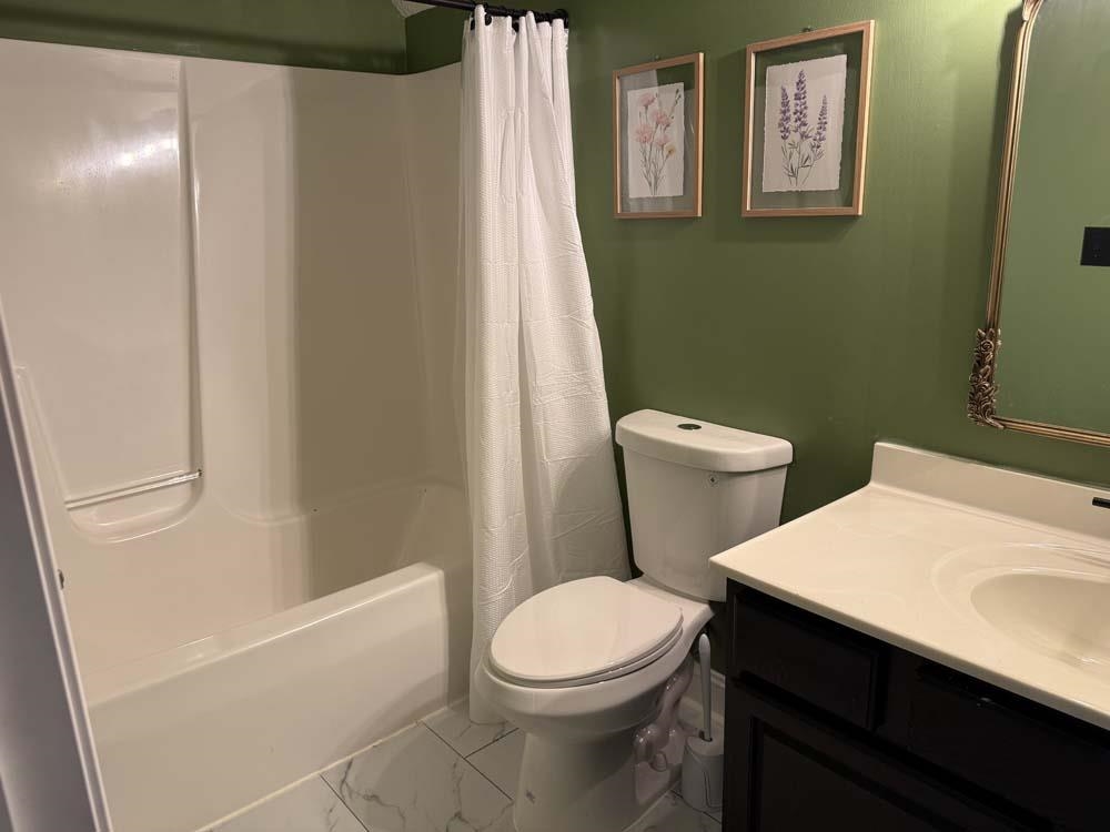 2179 Gainsboro Avenue Davis, IL 61019 - Photo 31 of 50 a white toilet sitting next to a bathroom sink and vanity