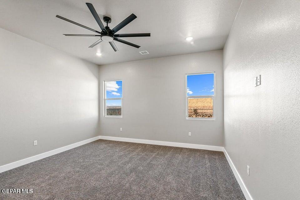 7353 Cimarron Rim Road El Paso, TX 79911 - Photo 12 of 30 an empty room with windows and ceiling fan