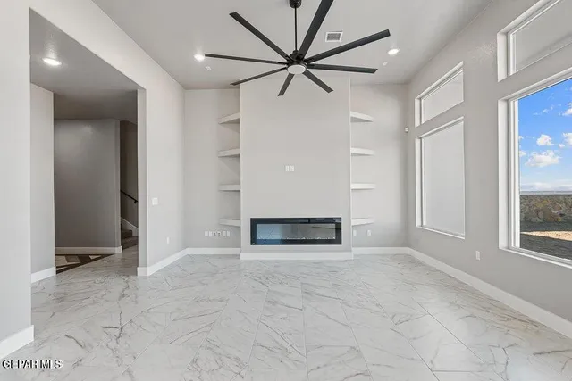 an empty room with windows and a ceiling fan