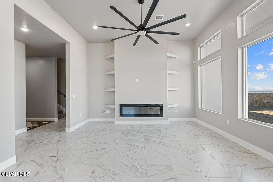 7353 Cimarron Rim Road El Paso, TX 79911 - Photo 6 of 30 an empty room with windows and a ceiling fan