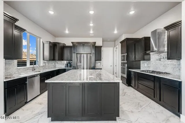 a large kitchen with kitchen island a sink stainless steel appliances and cabinets