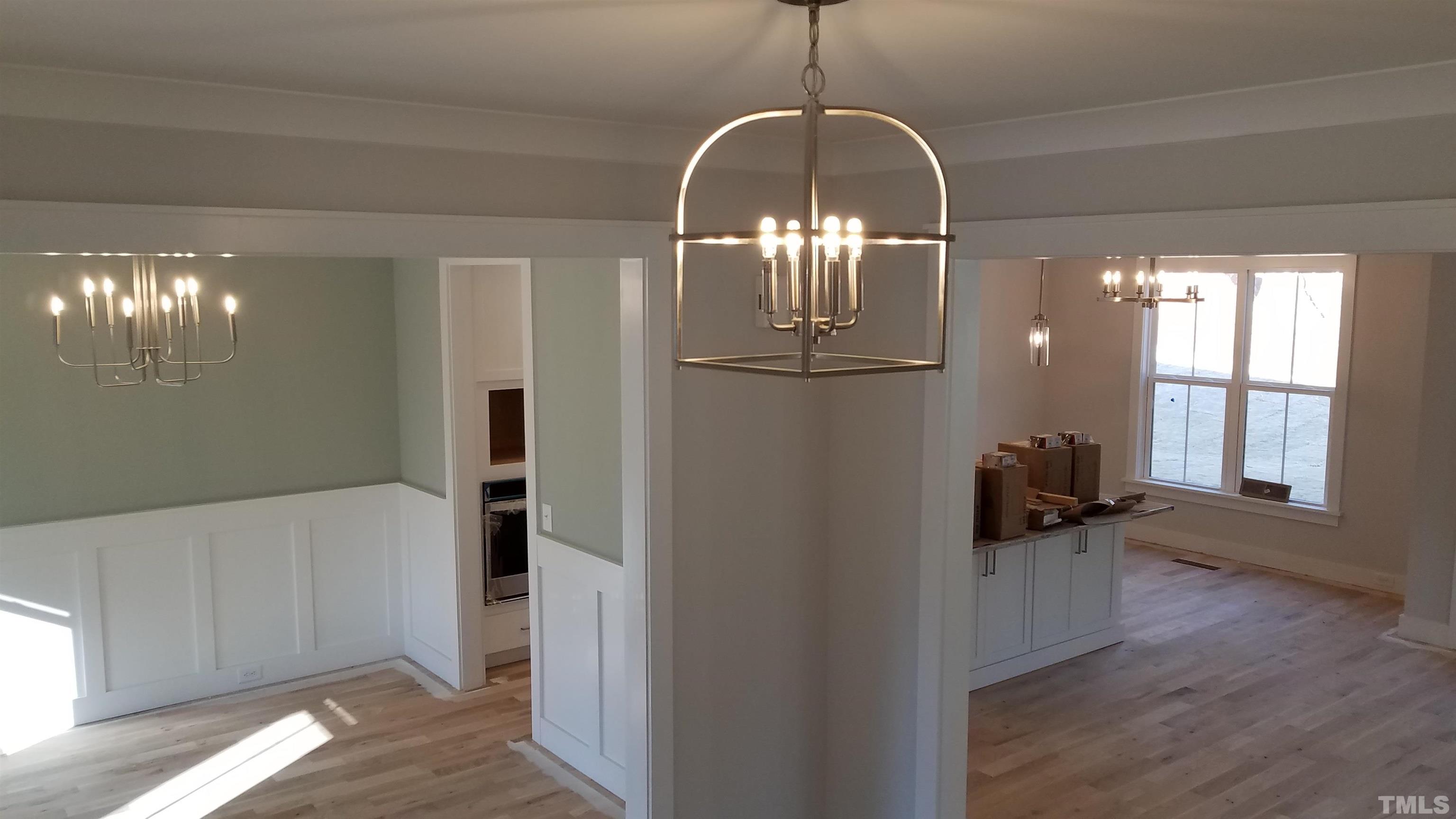6124 Blanche Drive Raleigh, NC 27607 - Photo 14 of 22 a view of a room with wooden floor chandeliers and kitchen
